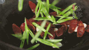 先后下香腸片、四季豆絲均勻翻炒，加適量清水燜煮一下。