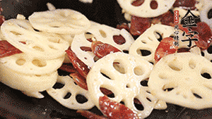 依次下香腸片、藕片翻炒均勻，加適量清水燜熟。