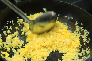 大火加熱炒鍋，再入油，燒到四至五成熱時倒入雞蛋液，在未凝結(jié)之前，加米飯煸炒，不停翻炒并用鍋鏟將成塊的米飯碾開、撥散。