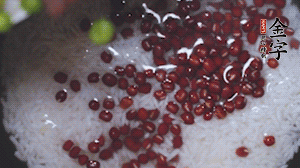 將炒好的食材和大米、紅豆一起放進(jìn)電飯鍋煮。