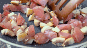 【餡料】4.鍋中油8成熱時(shí)，依次放入菌菇丁、香腸丁，適當(dāng)放點(diǎn)糖調(diào)味，炒熟。