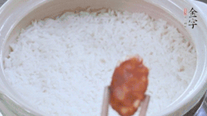 煮開后轉(zhuǎn)小火，當(dāng)米飯出現(xiàn)小孔時(shí)，鋪上金字麻辣香腸。