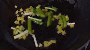 鍋中熱油，依次下姜粒、蔥段、蘆筍炒香。