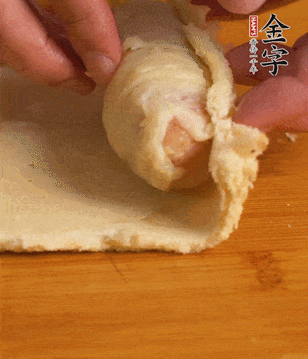 吐司卷起香腸，吐司尾端涂抹少許全蛋液，卷好的吐司表面蘸上蛋液，在裹上一層面包糠，送入預(yù)熱好的烤箱中。