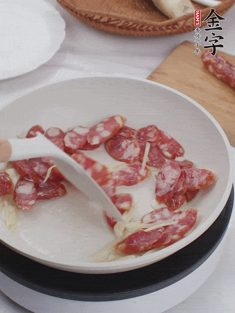 油溫3成熱時，下姜絲、蒜片、香腸炒出油脂。