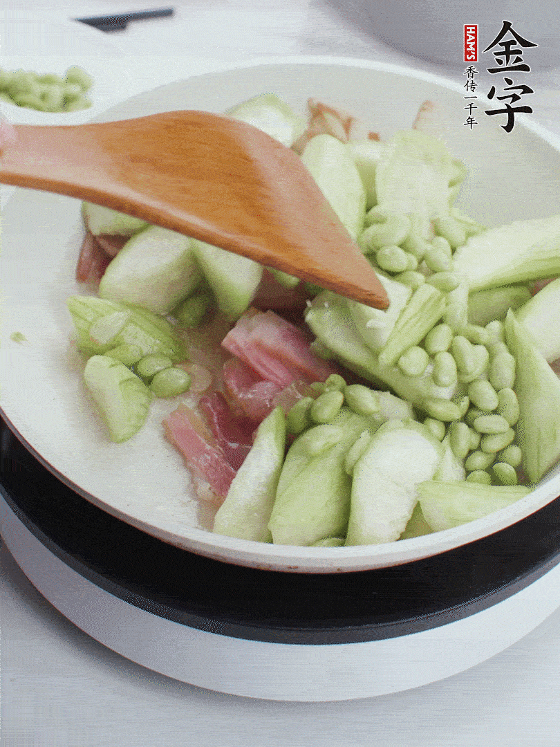依次下絲瓜、青豆翻炒，炒至絲瓜打蔫縮小。