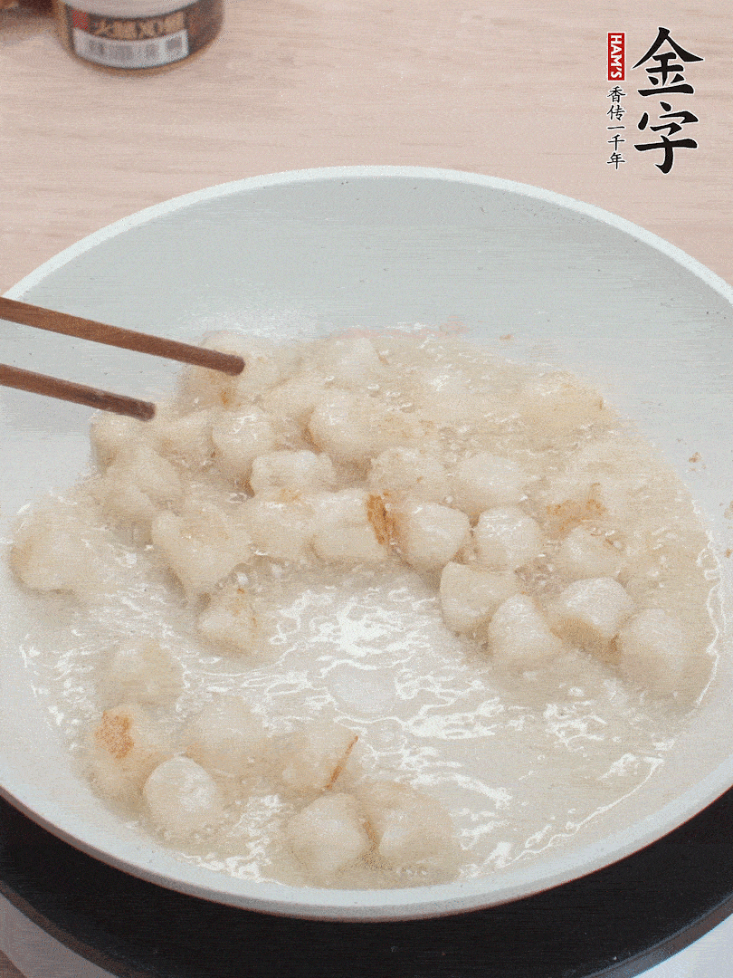 油溫4成熱，鮮貝蘸干淀粉下鍋煎，一面微黃后翻面。