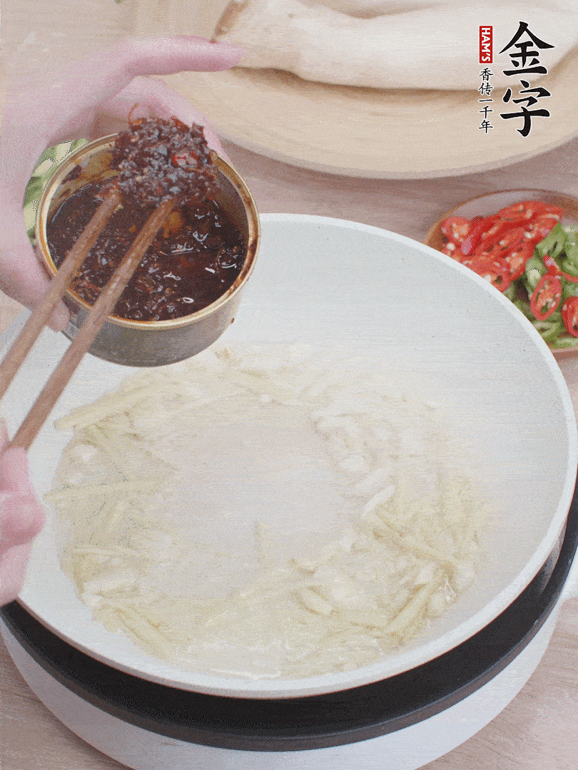 起鍋熱油，姜蒜、金字火腿干貝醬煸香。