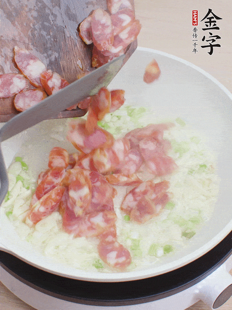 油5成熱，蒜末、蔥白爆香，下香腸炒出香味。