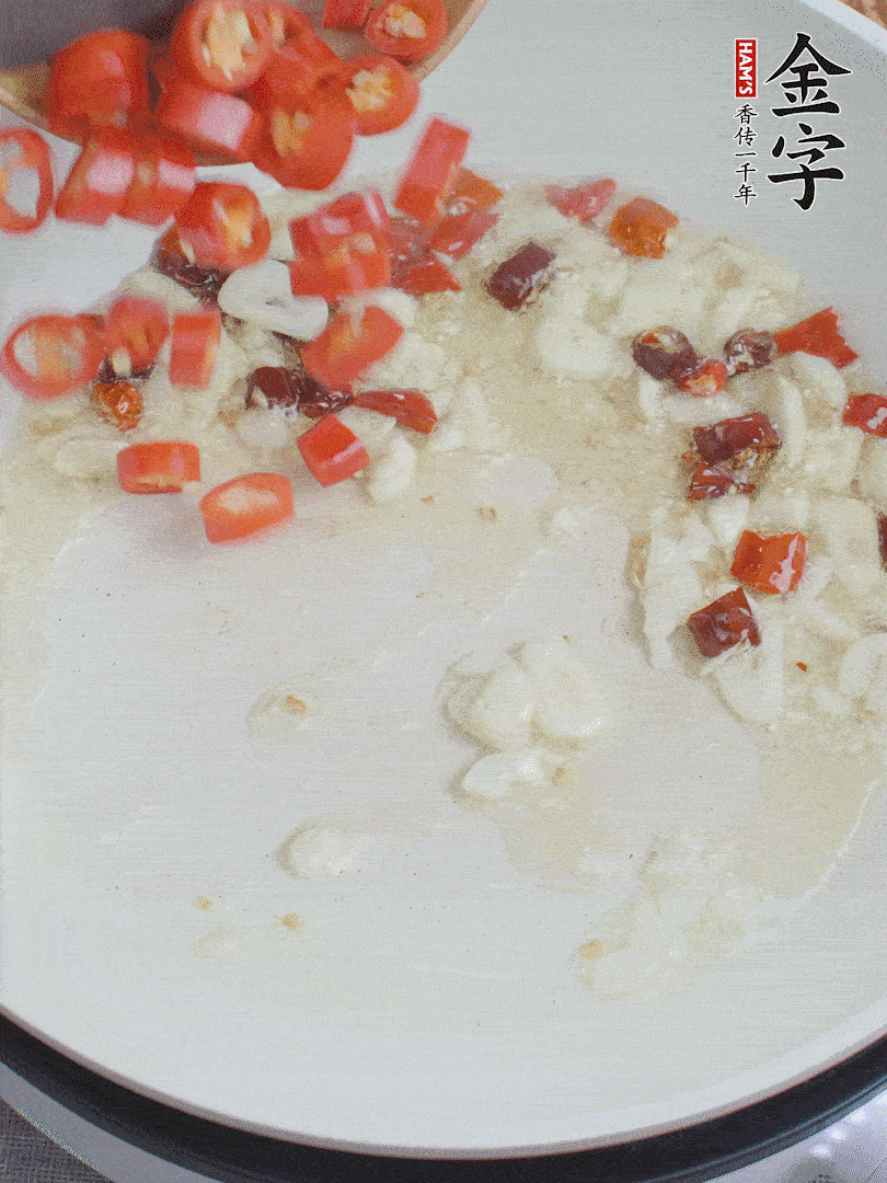 油6成熱，下蒜末、干紅辣椒煸炒，出香味后再放美人椒、香腸。