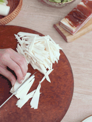 茭白切細(xì)絲，鹽水中浸泡防止氧化。