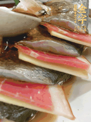 魚肚中塞蔥結(jié)、火腿片，魚身上碼放姜片、火腿片，倒入混合的料汁。