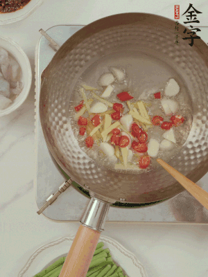 油7成熱時，下大蒜粒、姜絲、小米辣煸香。