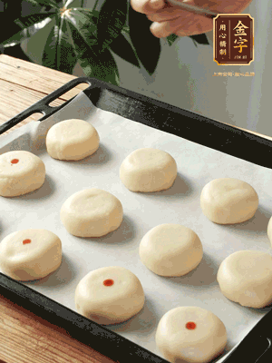 收口向下放在案板上，輕輕將月餅坯按扁，用筷子點(diǎn)紅點(diǎn)做裝飾