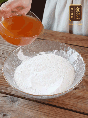 轉化糖漿、枧水、花生油攪拌均勻，加入面粉混合，醒發(fā)2小時。捏成23g一個的小球