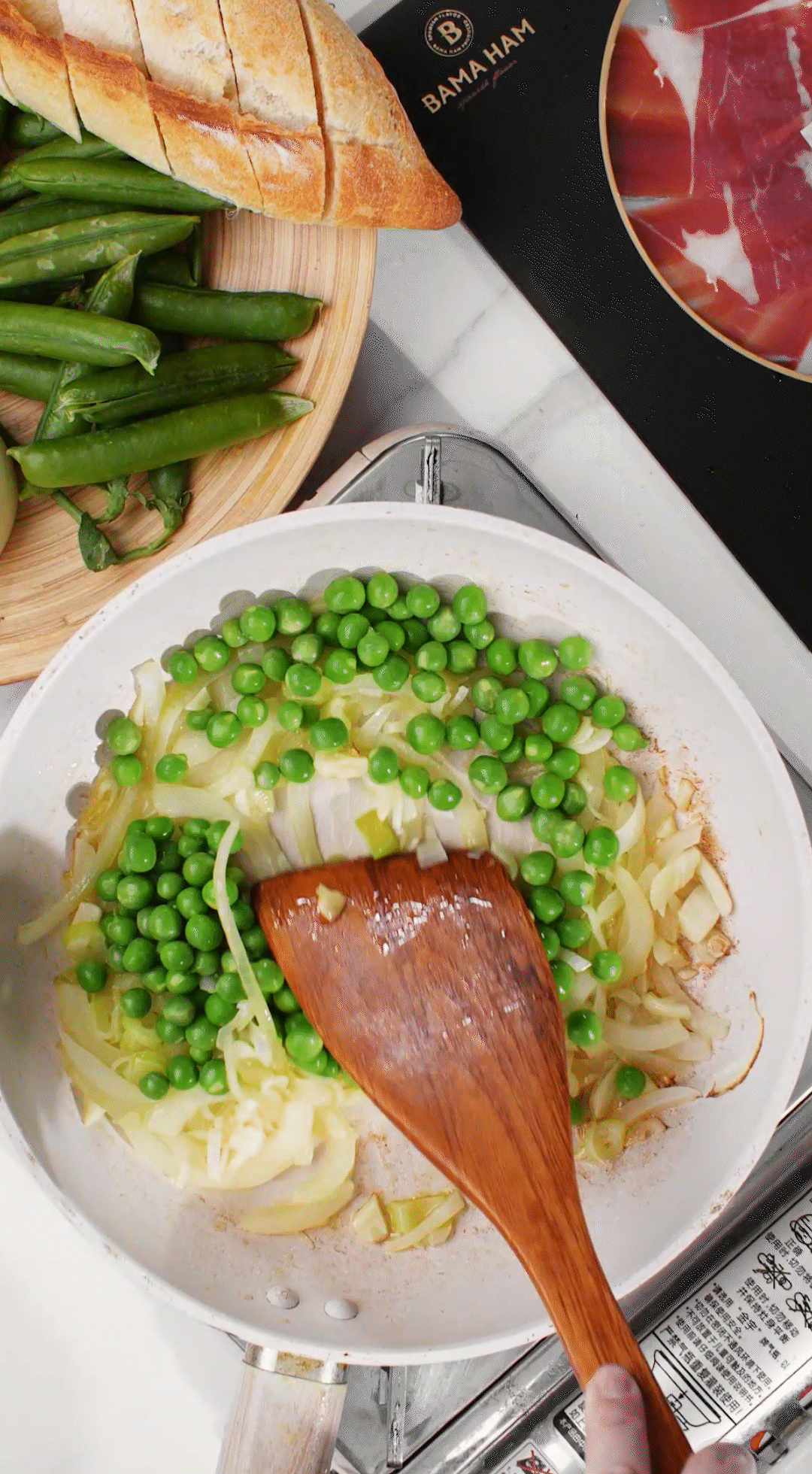 鍋中放入黃油融化，加入洋蔥絲、大蔥蔥白絲、蒜末翻炒變軟出香味。加入剛剛汆燙冰鎮(zhèn)后的豌豆，取出一點點待會擺盤裝飾用。加一點鹽 (和黑胡椒) 調(diào)味。