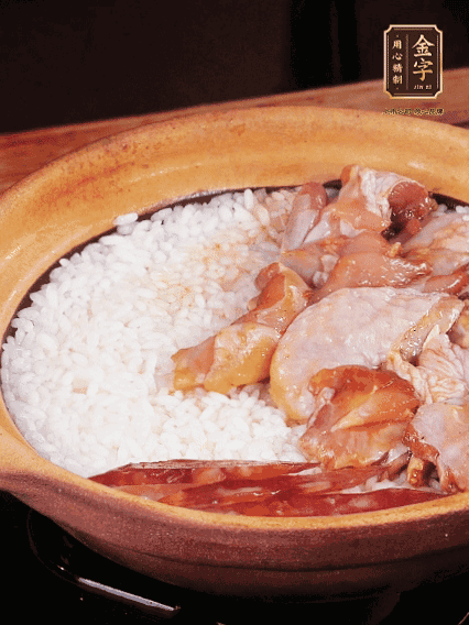 煮到椰子水微微收干轉(zhuǎn)小火，快速均勻鋪上雞肉、金字香腸