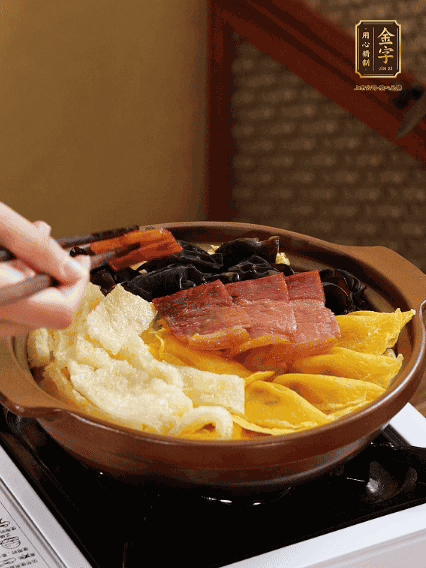 砂鍋底部鋪上娃娃菜，依次擺上肉皮、蛋餃、黑木耳、火腿